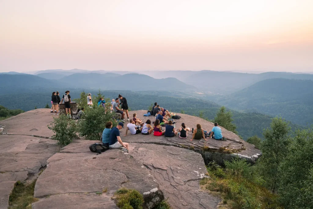 Nombreux visiteurs profitant du coucher du soleil au sommet du Donon dans les Vosges.