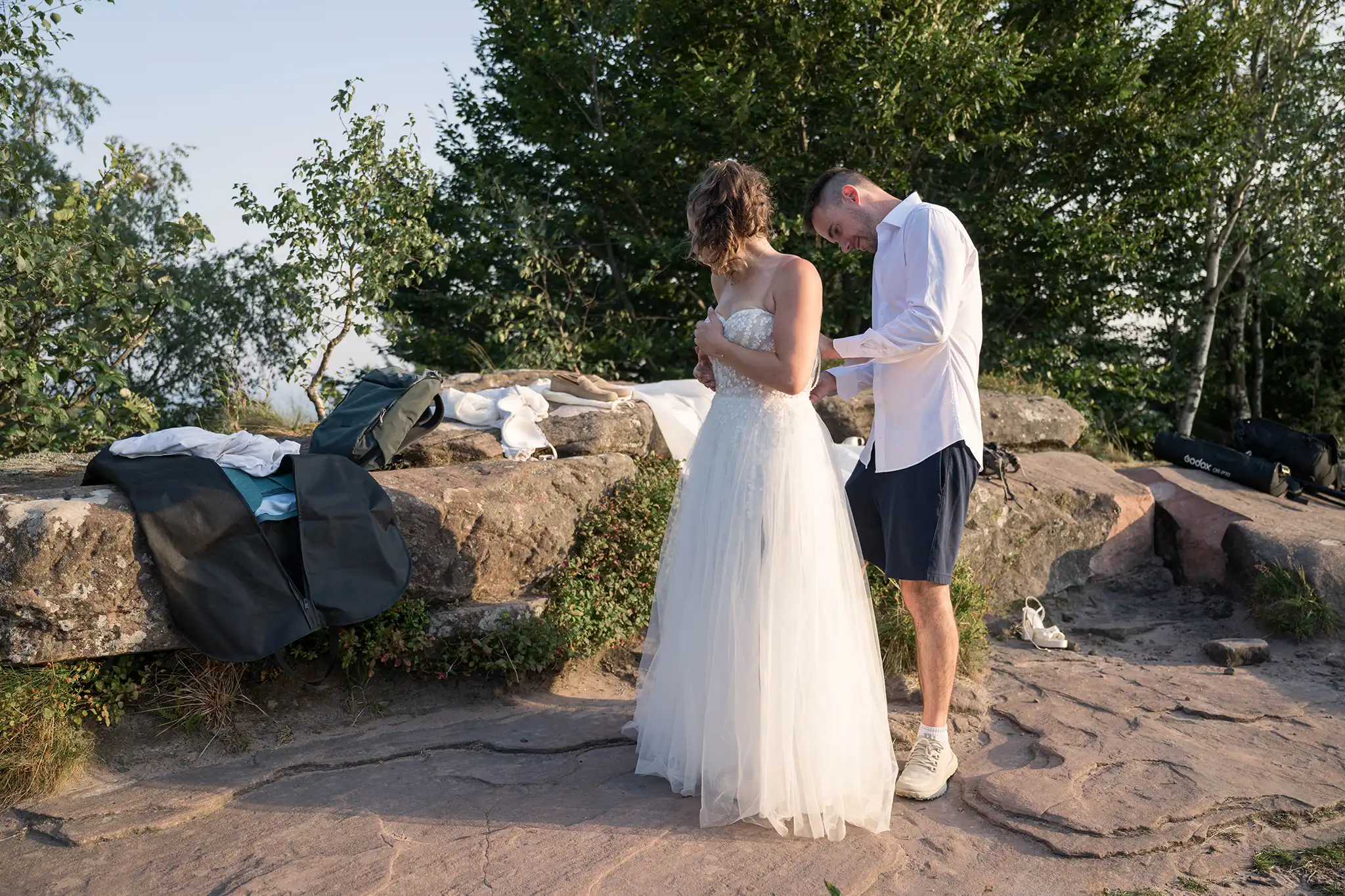 Les mariés enfilent leurs tenues de mariage au sommet du Donon avant une séance photo day after dans les Vosges.