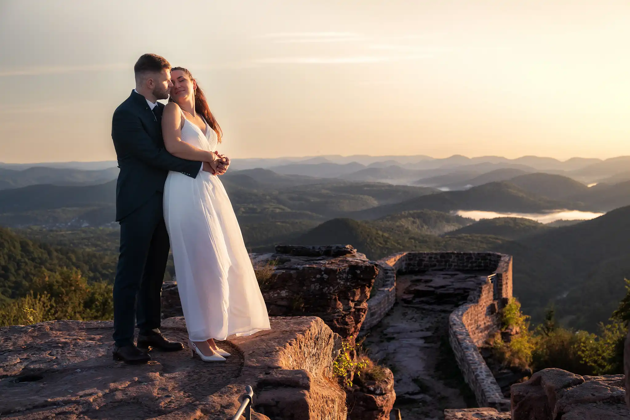 Mariés au coucher du soleil sur les ruines du Château du Wegelnburg avec vue sur les Vosges du Nord