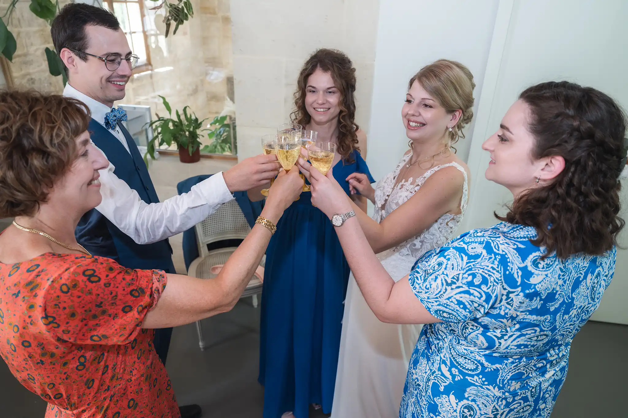 Mariée trinquant avec ses témoins et sa famille pendant les préparatifs du mariage